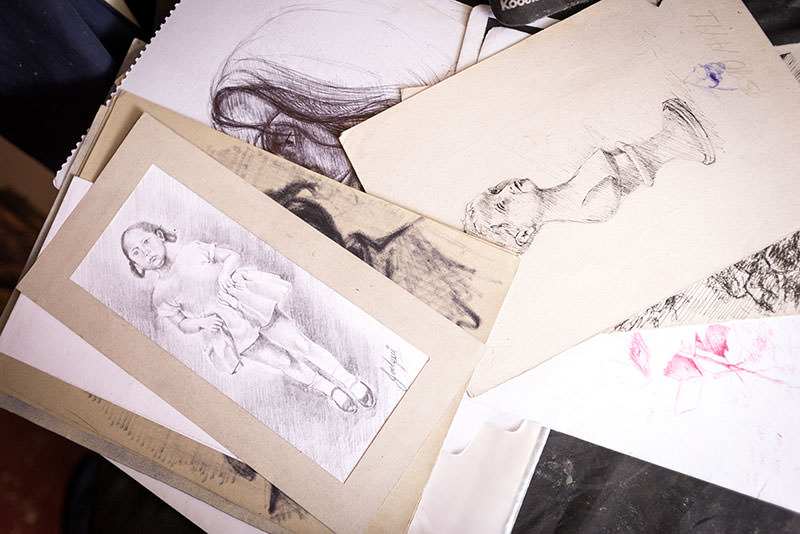 A stack of sketches — pen and ink, charcoal, and pencil — show the range of Joel’s artistic talent and skill.