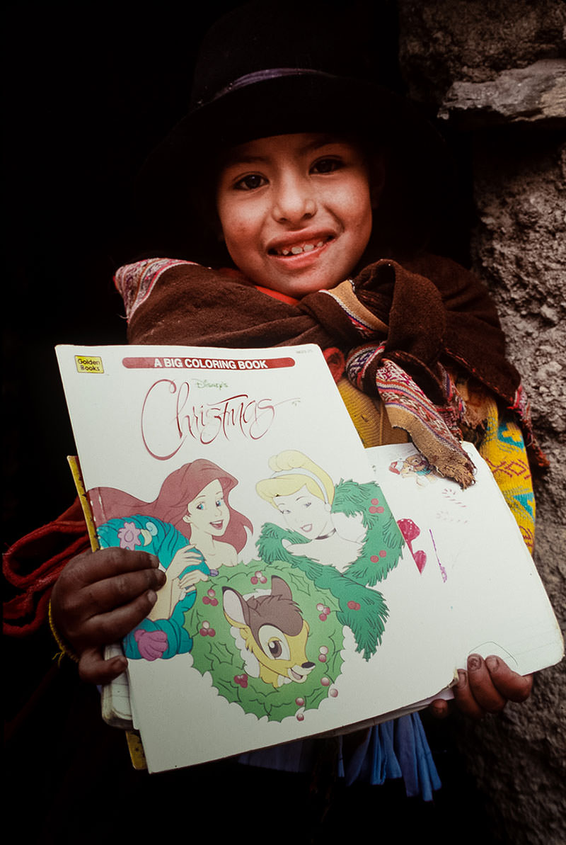 In 1997, Silvia Rafaelo Curo, 8 (Ortencia Rafaelo Curo’s older sister), treasured gifts from her U.S. sponsor, including a coloring book. World Vision staff had to carry in all sponsor correspondence and presents as they reached villages like Carhuahurán on foot.
