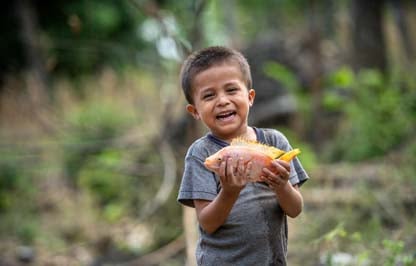 little boy holding fish