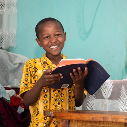 boy smiling holding a bible
