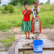 two girls at water pump