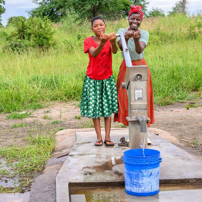 two girls at water pump