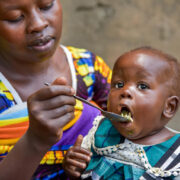 Mother feeds baby with a spoon
