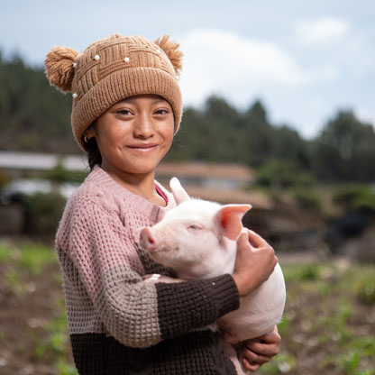 Young girl smiles and holds the gift of a pig