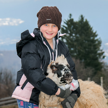 kid with a sheep in a cold weather