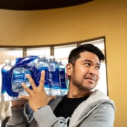 man carrying water bottles on his shoulder