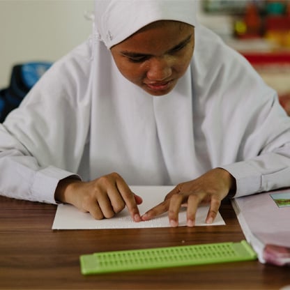 girl reading in braille