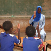 teacher and children using sign language in a classroom