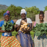 three women holding food from the garden