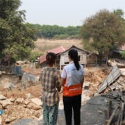 two people standing next to each other looking at a disaster