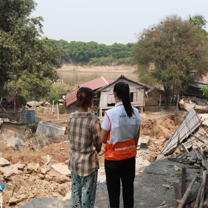 two people standing next to each other looking at a disaster