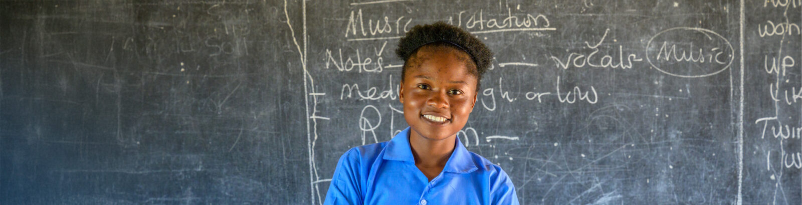 young lady standing in front of chalkboard