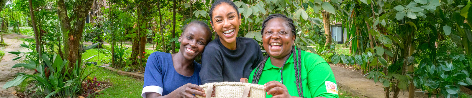 three women laughing and smiling while holding a basket