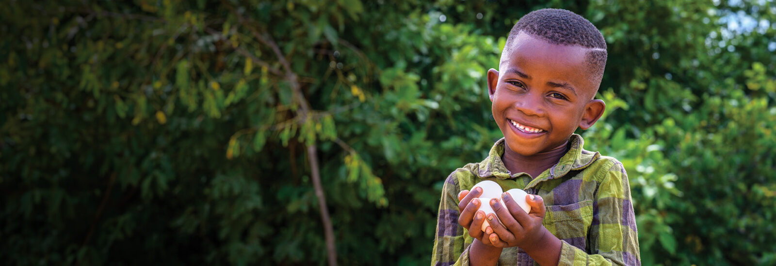 little boy smiling holding eggs