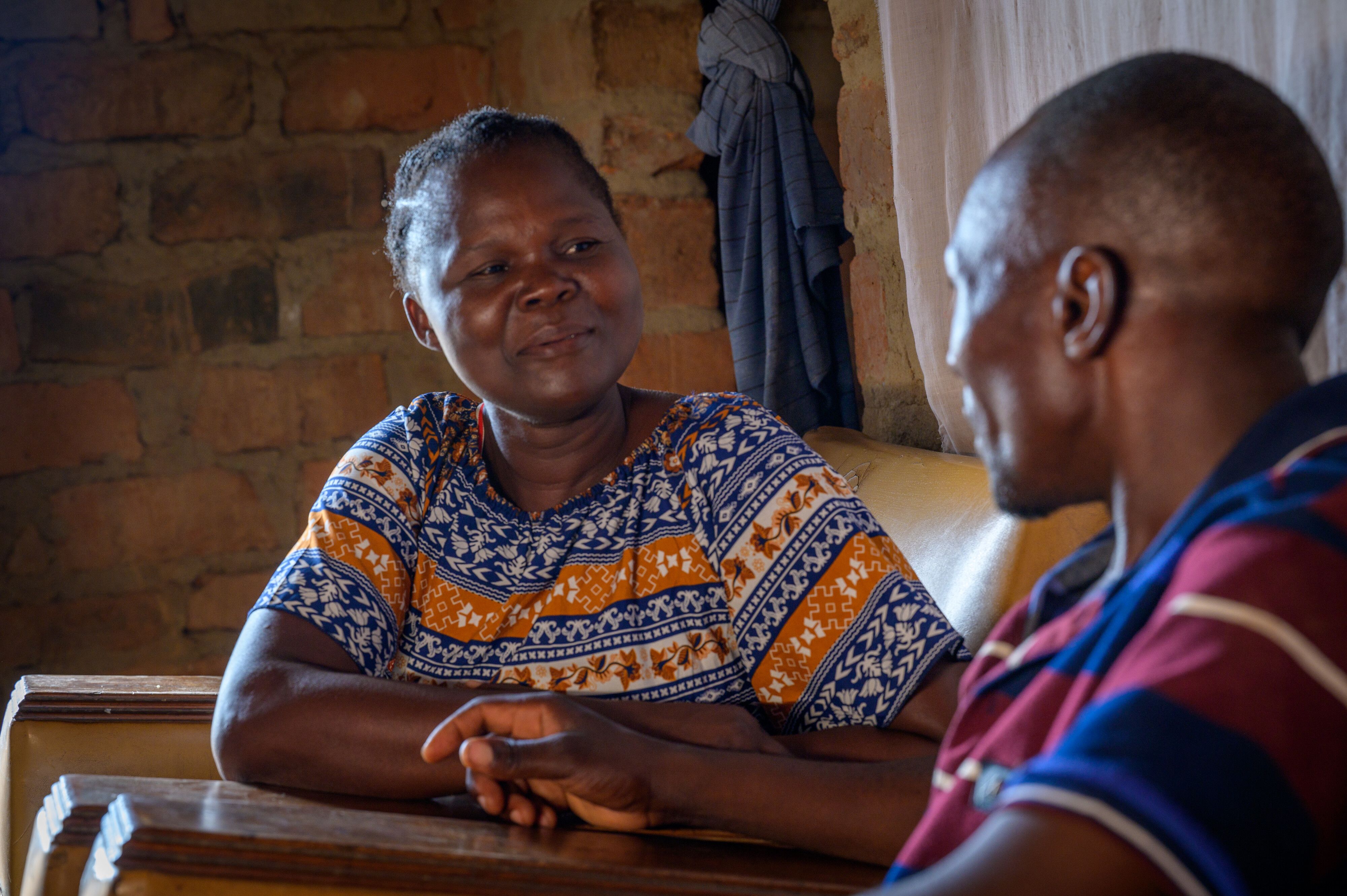 A woman smiles as she looks into the face of the man sitting next to her.