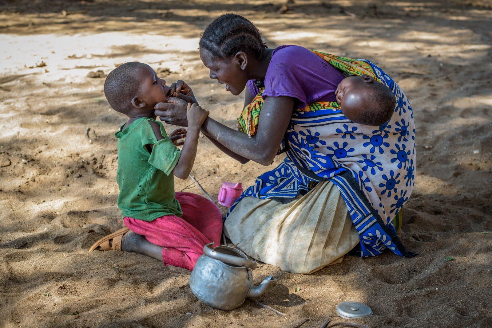 Monica uses a twig to clean Cheru’s teeth in a break from their long walk for water.