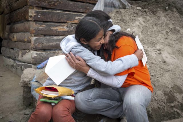 A World Vision staff member hugs an 11-year-old girl who received a package from her sponsor. Learn what the Bible says about generosity.
