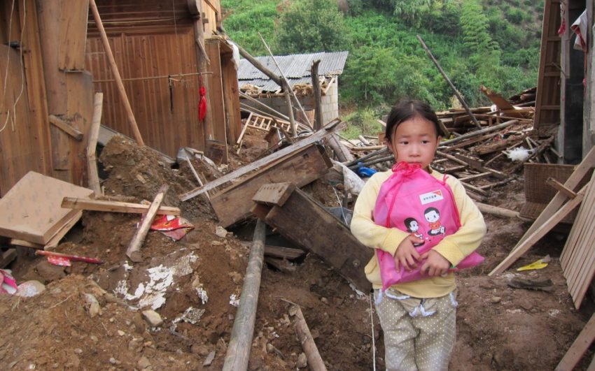 A girl clutches a bag amid destruction. Pray for East Asia.