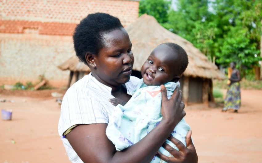 African woman holding baby, who has pneumonia.