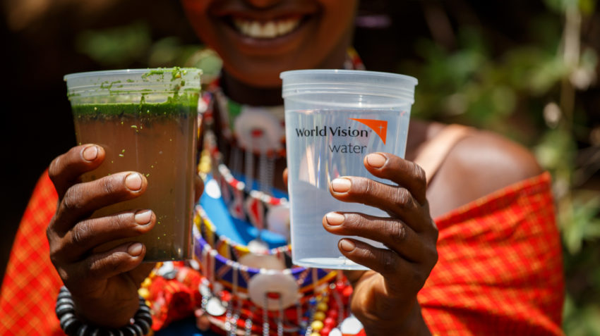 The global water crisis no more for this woman in Kenya who holds up a cup of dirty, contaminated water next to a cup of clean, safe water.
