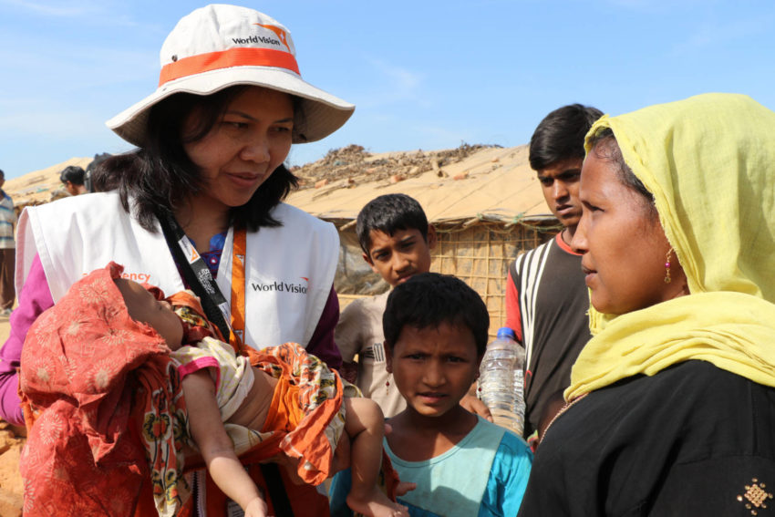 World Humanitarian Day: World Vision Regional Field Director Buli Hagidok holds a baby as she talks with a refugee family in a camp in Bangladesh. Home to 886,000 refugees, this camp is the largest, most densely populated in the world.
