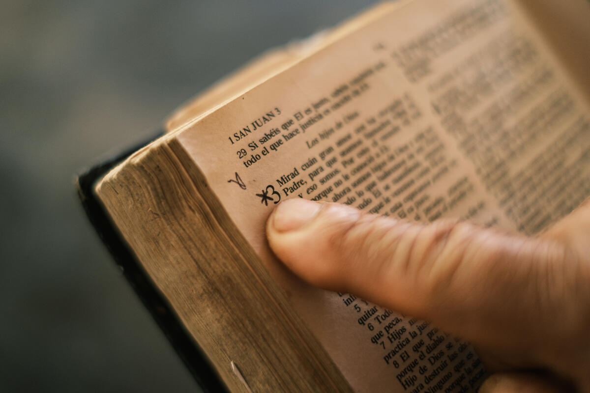 A close-up photo of the book of John, in Spanish, with a finger pointing to the start of chapter three. A star is written next to it.