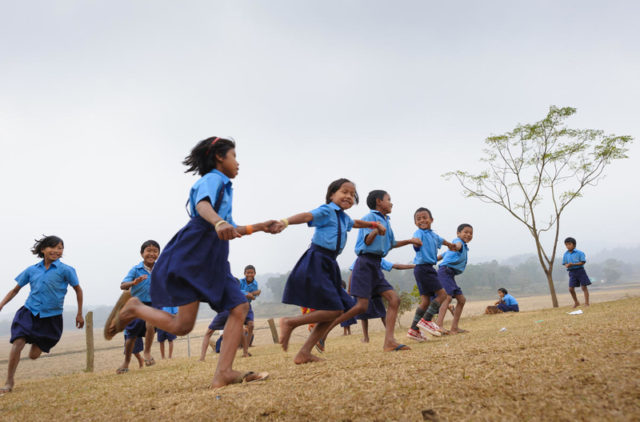 Children, many of them sponsored, play games and attend class at a school in India. World Vision provided the furniture for the school.