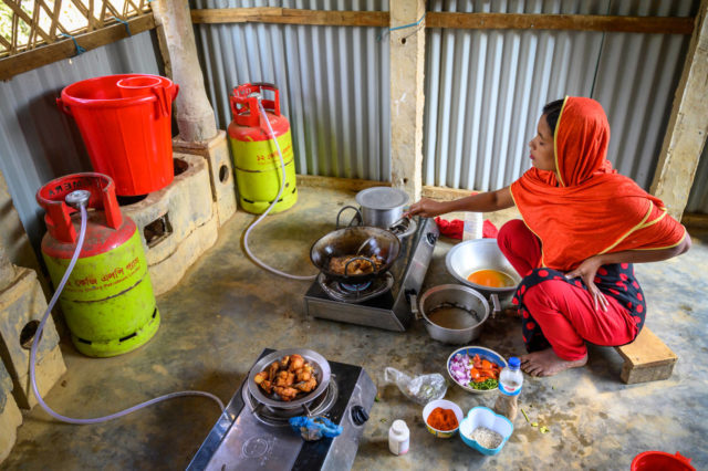Woman cooks on a two-burner gas stove