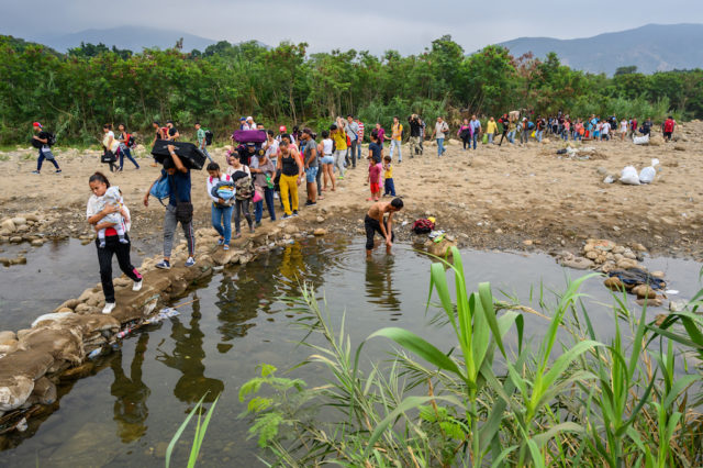 People walk away from Venezuela and across the Tachira River to Colombia.