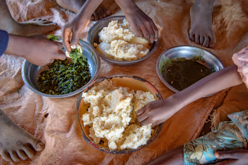 Zambian children share a lunch of nshima, boiled greens, and mundyoli.