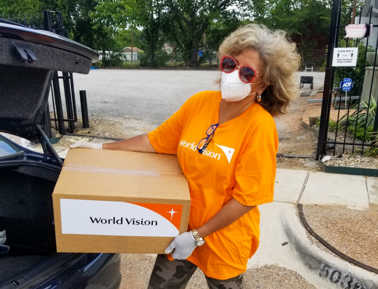 Pastor Helen Epps loads a World Vision Family Emergency Kit into a car