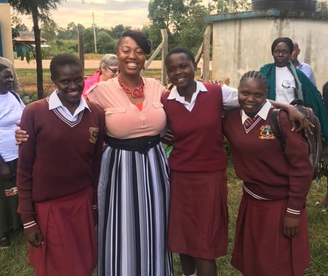 Lora Williams stands with three Kenyan girls in their school uniforms.