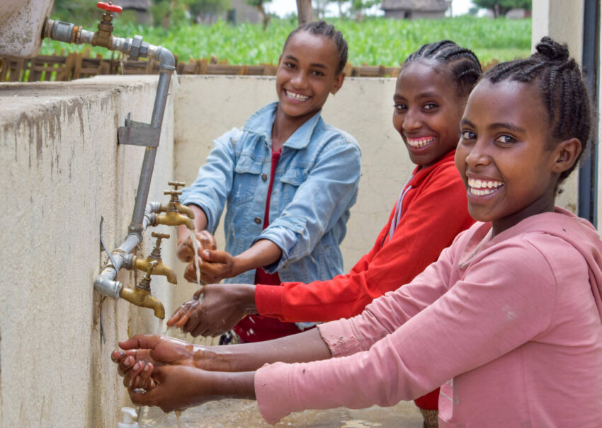 Three Ethiopian girls wash their hands.