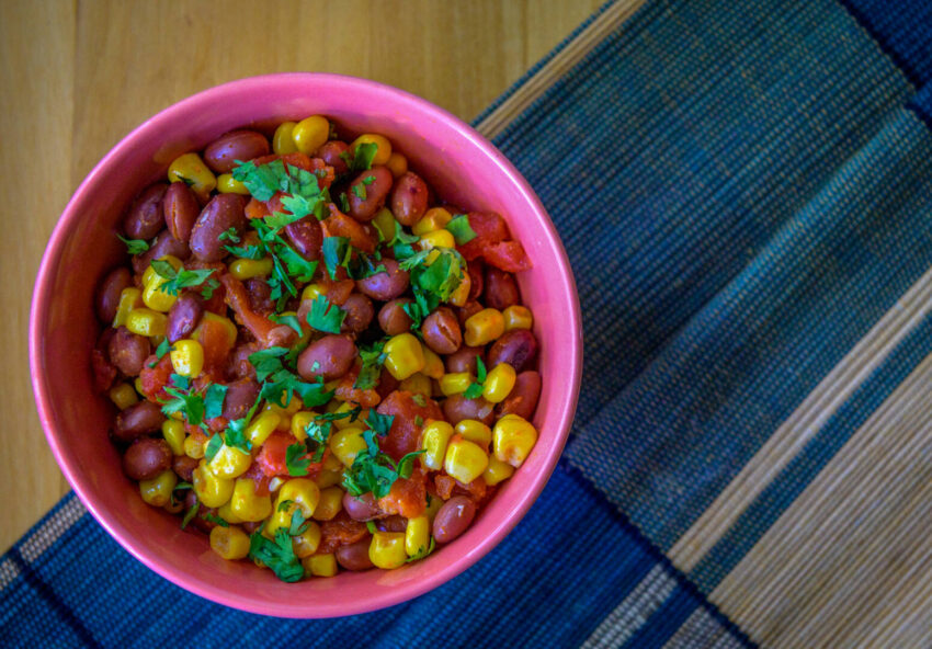 A bowl filled with a Kenyan recipe called githeri, which consists of red beans, corn, and tomatoes.