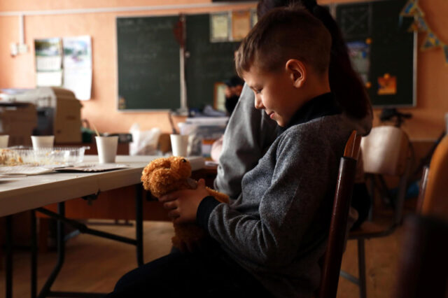 boy plays with a new teddy bear provided by Divchata for psychosocial support.