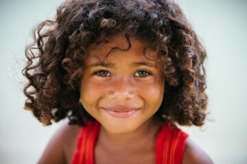 Close-up shot of a young girl softly smiling.