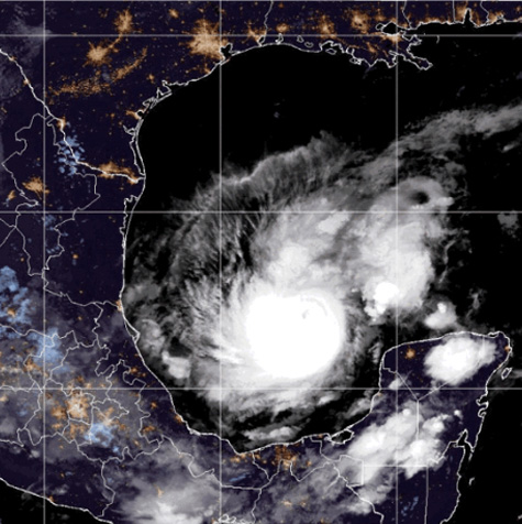 A satellite image shows a massive well-defined, swirling cloud structure moving in the Gulf of Mexico.