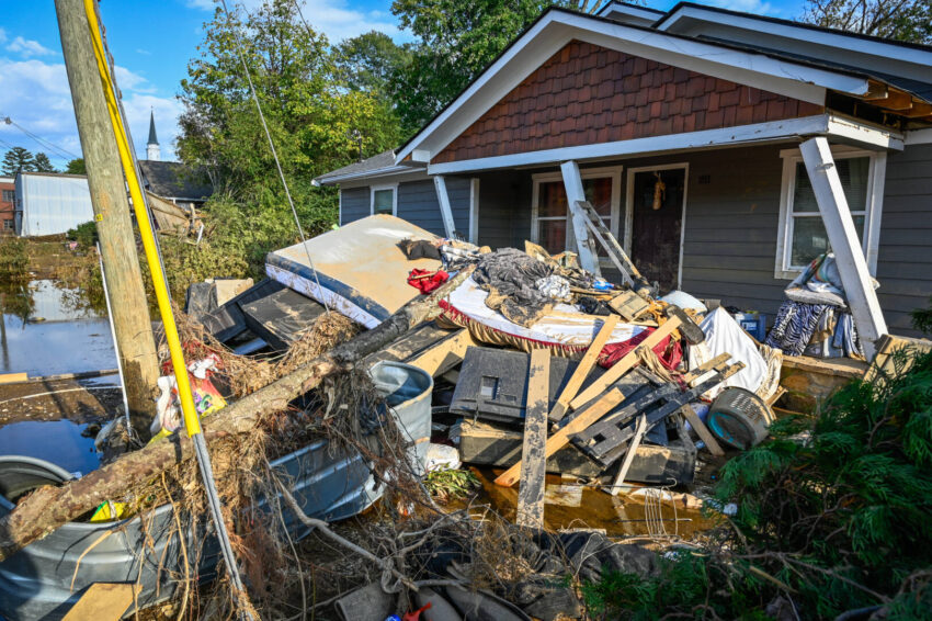 Debris piled near a damaged doorstep of a home in North Carolina on a sunny day.