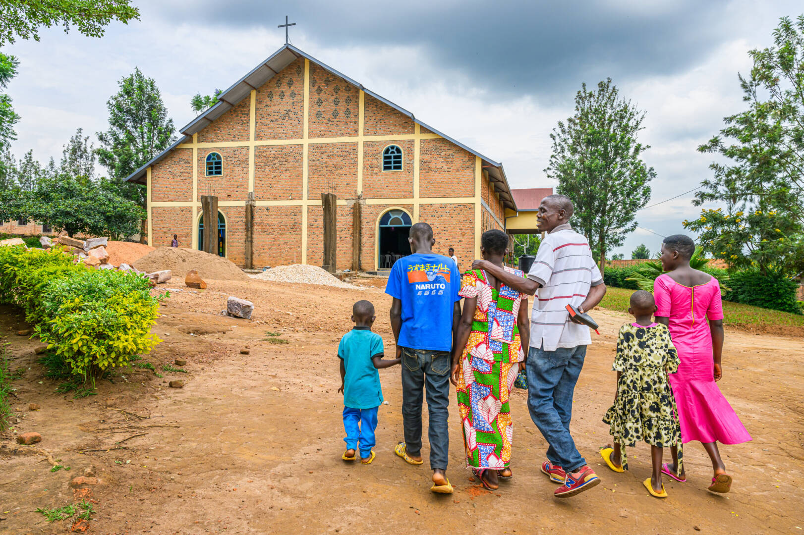 A family of six walks toward a church in Rwanda.