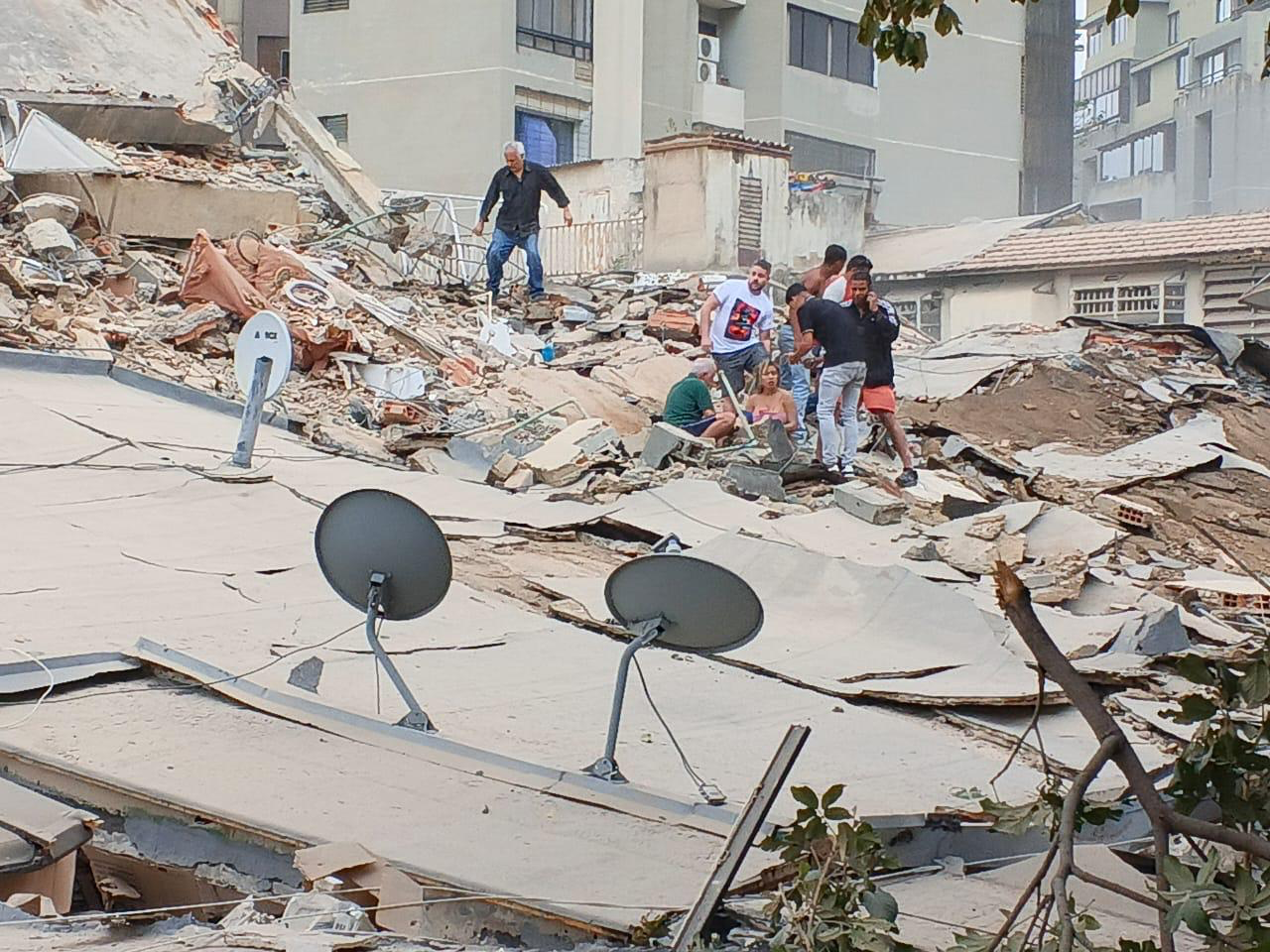 Men stand in rubble in the aftermath of a magnitude 7.2 earthquake in Venezuela. 