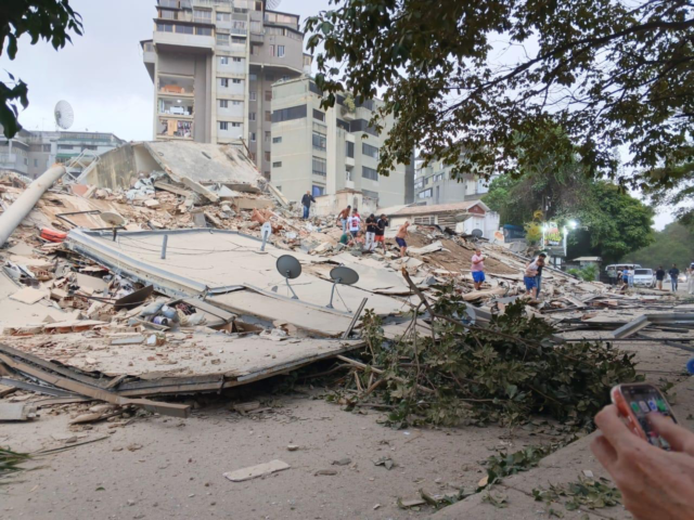 People stand on toppled buildings in Venezuela after earthquake.