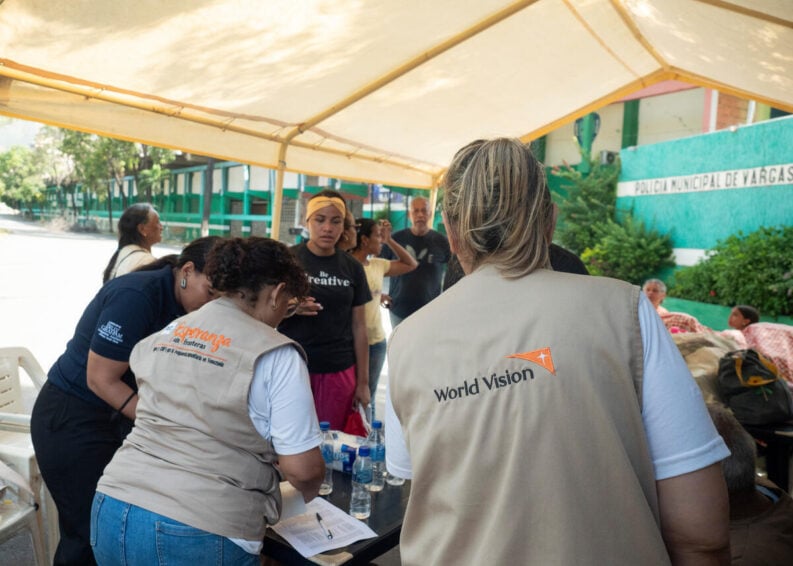 Aid workers and people underneath a tent following the earthquake.