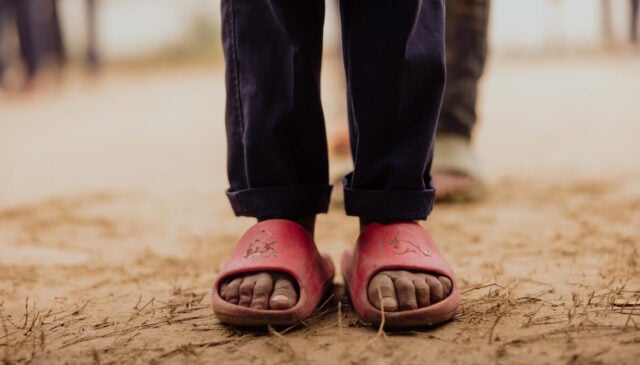 Close-up of a young girl’s feet in shoes, illustrating empathy through the idea of walking in someone else’s shoes.
