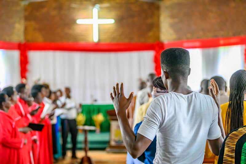 A male member of a Rwandan church raises his hands during a Sunday service.