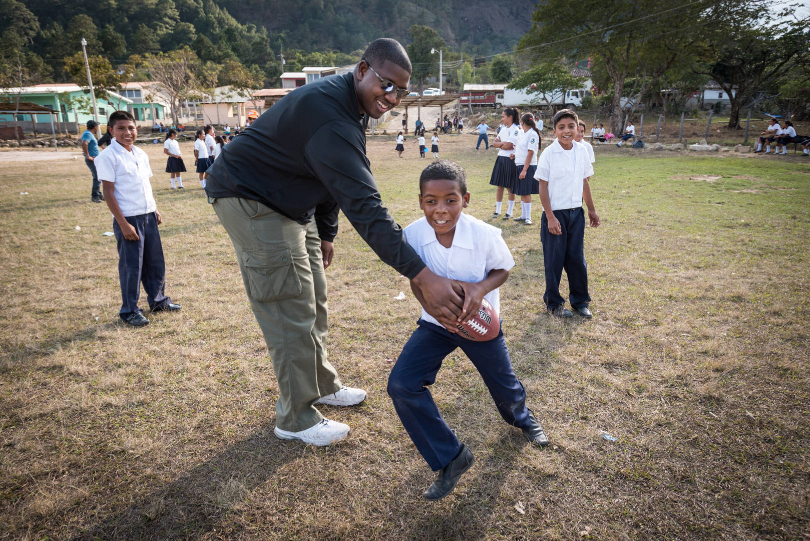 NFL player Kelvin Beachum, Jr. plays American football (Fútbol Americano) with students from World Vision's Agua Blanca project and peer-to-peer tutoring program in San Juan, Honduras.