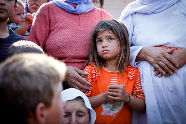 Six-year-old Salma and her family walked for eight days before they arrived in Dahuk, Iraq. They're living in a shelter made of cardboard and blankets on the grass next to a service station. (©2014 Meg Sattler/World Vision)