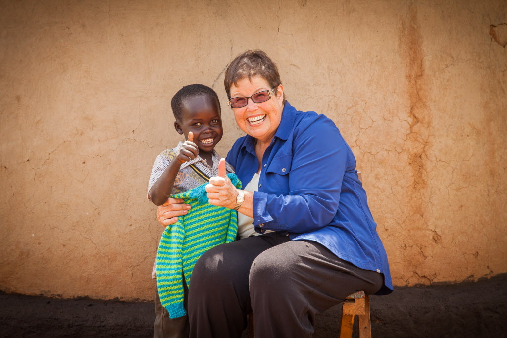 Debbie Macomber gives Kenyan boy sweater ©2014 Lindsey Minerva | World Vision