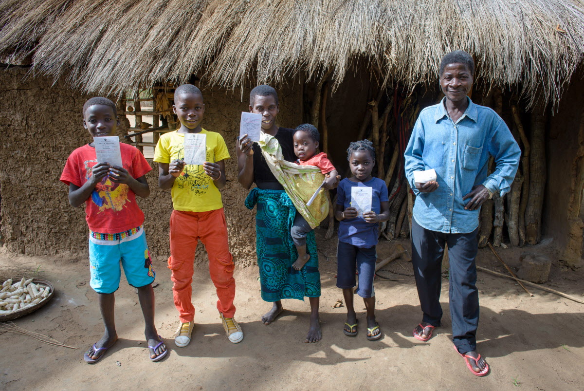 family in Mozambique holding birth registration cards
