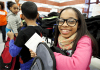 A girl smiles after receiving her backpack stuffed with school supplies and a hand-written note during World Vision New York Day of Caring on December 14. PHOTO: ©2013 Juliette Lynch / Genesis Photos