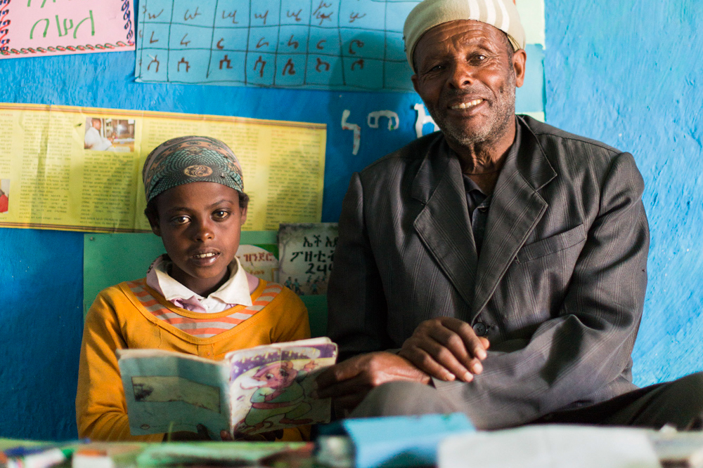 In Ethiopia, Seble and her grandfather share a book in the reading corner they made together. (©2015 World Vision, Max Greenstein)